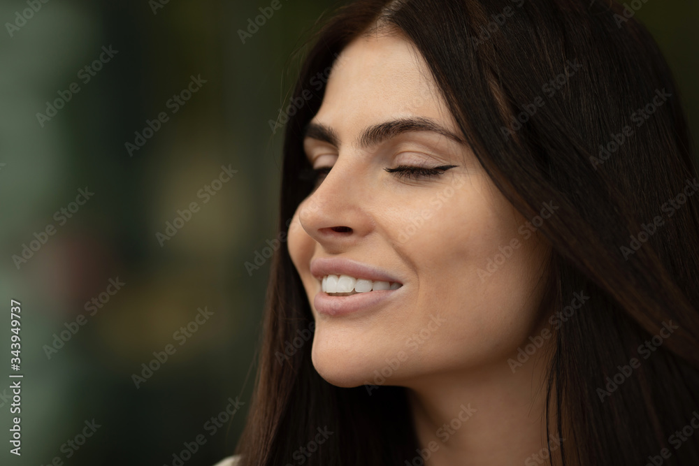 Portrait Of Young Beautiful Woman. Beautiful young brunette fashion model posing outdoor. Summer outdoor portrait. Focus on woman, blurred background.