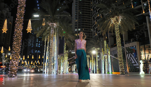 Photography A young woman is walking along the evening Dubai.