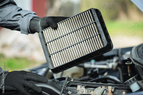 Schilderij op canvas A car service worker is showing in hands old car air filter close up