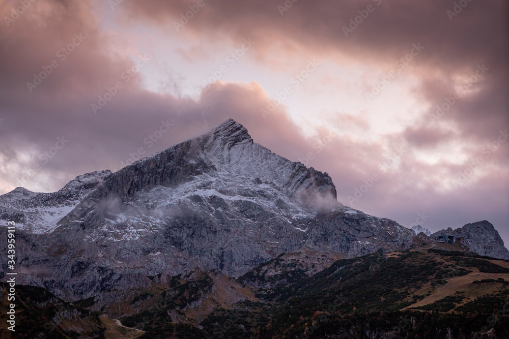Sunset view of snow covered mountain peak Alpspitze with clouds in sky, landscape in autumn, Garmisch-Partenkirchen Bavaria. Sunset view of snow covered mountain peak Alpspitze with clouds in sky, landscape in autumn, Garmisch-Partenkirchen Bavaria.