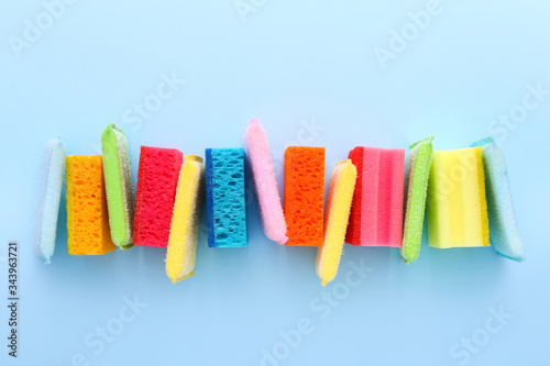 Colored kitchen sponges on blue background. Kitchen cleaning set