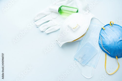 Set of protecting disposable аntiviral various filtering safety face masks, gloves, sanitizer for hands on blue background. Protection against flu and coronavirus, pollution, virus. Stop virus.