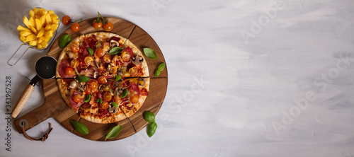 Tasty pizza and fries on wood serving board, white background. Overhead horizontal image, room for text