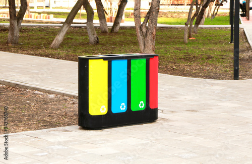 four waste sorting baskets on the city street for paper, plastic, glass and unsorted garbage