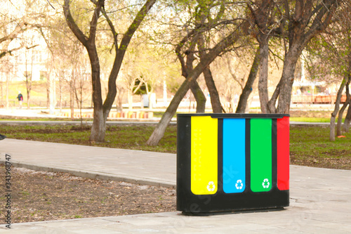 four waste sorting baskets on the city street for paper, plastic, glass and unsorted garbage