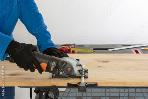 Carpintero cortando madera con sierra de disco photo