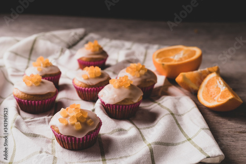 Candied fruit orange muffins on a white towel. 