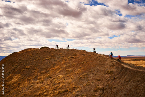 Mountain bikers riding on mountain ridge photo