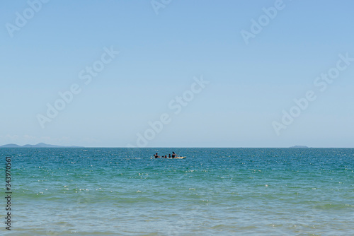 View of beautiful beach in Florianópolis, Brazil. Two men kayaking in the turquoise sea under beautiful clear sky on vacation day in tropical summer. Concept of outdoor activity in contact with nature © Divina Epiphania