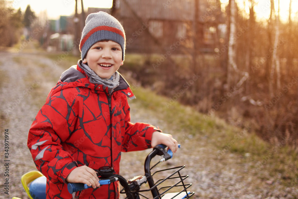 Obraz premium Boy on bike. Child is riding on street. Happy child is playing outdoors.