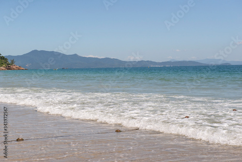 Beautiful beach in southern Brazil - City of Florianopolis. Beautiful view of greenish sea. Cloudless sunny day - clear sky in the summer.