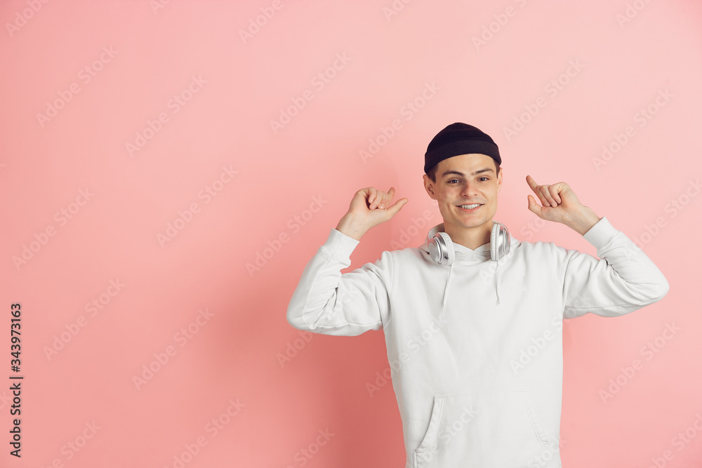 Pointing, choosing. Caucasian young man's modern portrait isolated on pink studio background. Beautiful male model in white. Concept of human emotions, facial expression, sales, ad. Copyspace. Pointing, choosing. Caucasian young man's modern portrait isolated on pink studio background. Beautiful male model in white. Concept of human emotions, facial expression, sales, ad. Copyspace.