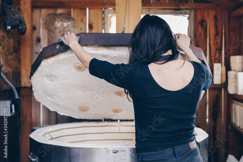 artist awaits body casting infused glass piece from out of the kiln photo