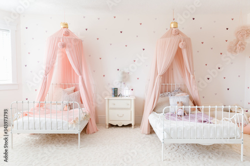 sister room with matching beds and pink canopies photo