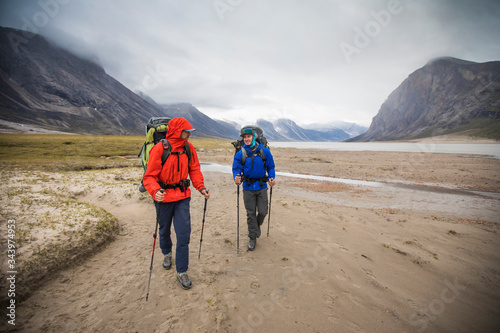 Front view of backpackers hiking in the rain, Baffin Island, Canada. photo