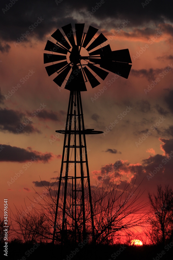 windmill at sunset with clouds in Kansas
