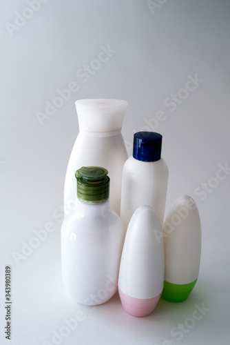 Jars of care products in white in various shapes and with different lids on a light background
