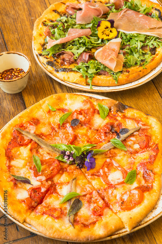 margherita pizza and a proscuitto and arugula pizza