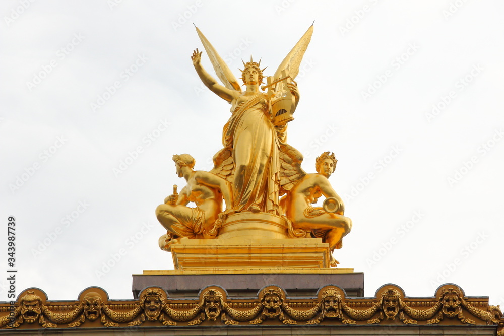 One of the two golden statues on the roof of the Opera House, Palais Garnier in Paris, France