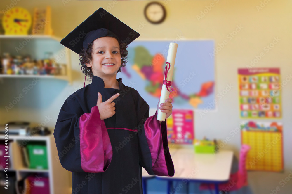 Niño graduado con toga y birrete fin de cursos preescolar salón de clases  graduación Stock Photo | Adobe Stock