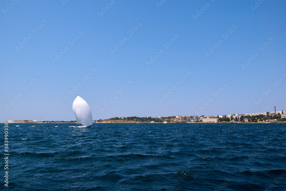 A yacht under white sails in the black sea. Sevastopol - August 9, 2016.