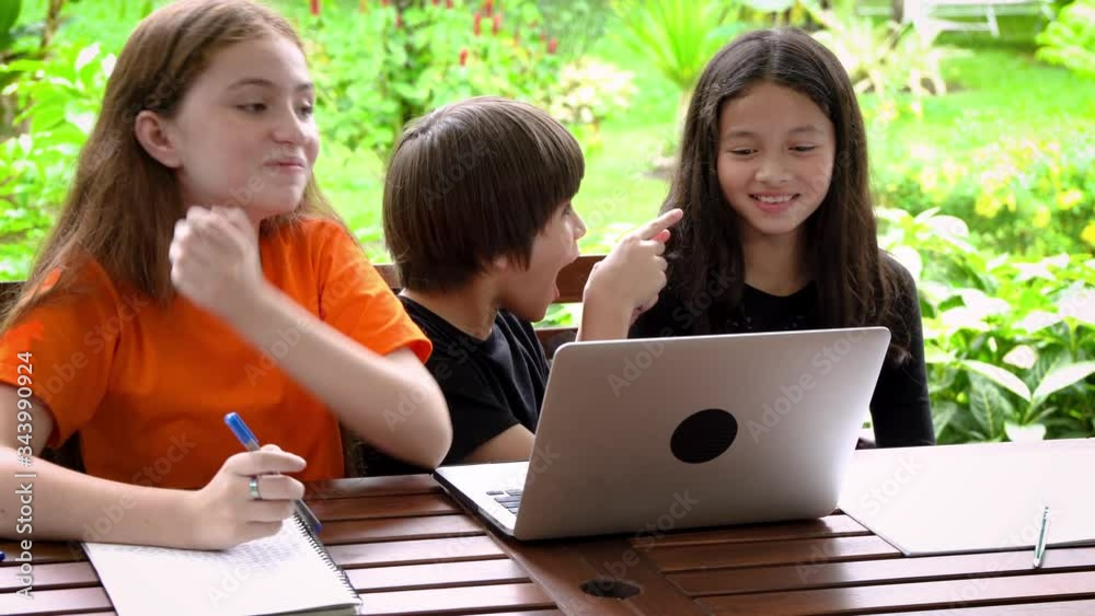 Children, boy and girl, using laptop computer for online learning in garden at home