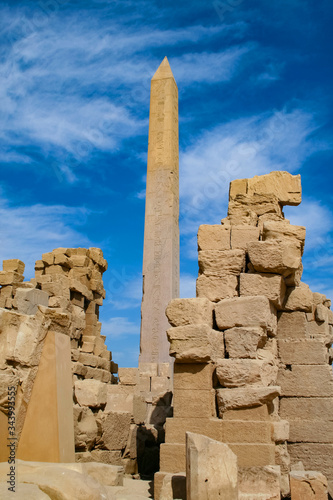 Obelisk of Queen Hatshepsut at the temple of Karnak in Luxor with hieroglyphic carvings on blue sky background