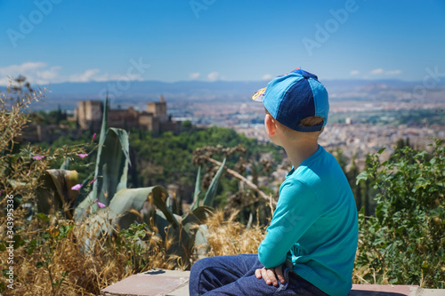 A child looks at the panoramic view of the Alhambra.