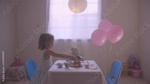 Young Girl Playing Tea Party with Stuffed Animals