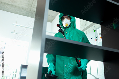 Experienced specialist disinfecting frequently touched surfaces indoors