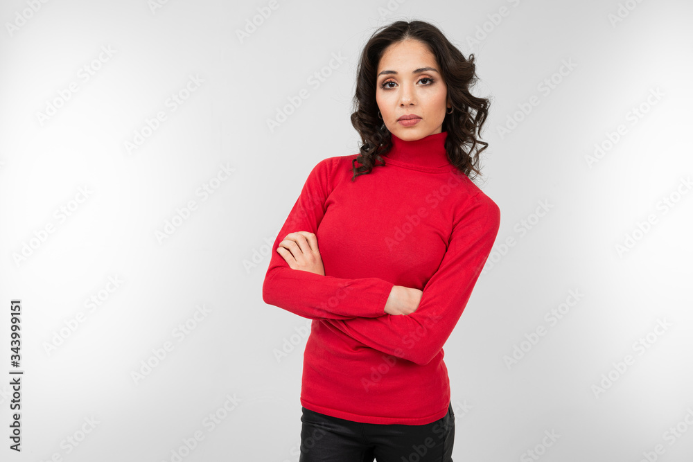 lovely brunette girl in a red tight fitting sweater stands confidently with her arms crossed fart by herself on a white background with copy space Stock Photo Adobe Stock