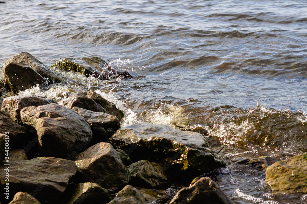 Rocky riverbank. Waves rise against rocks. Rocky riverbank. Waves rise against rocks.