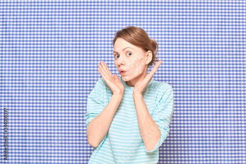 Portrait of surprised girl with white spots of cosmetic on face