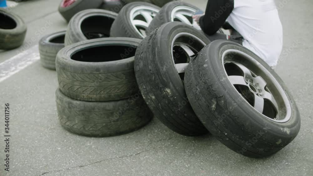 Two heavily worn sets of wheels lying on new tires in line for replacement Two heavily worn sets of wheels lying on new tires in line for replacement