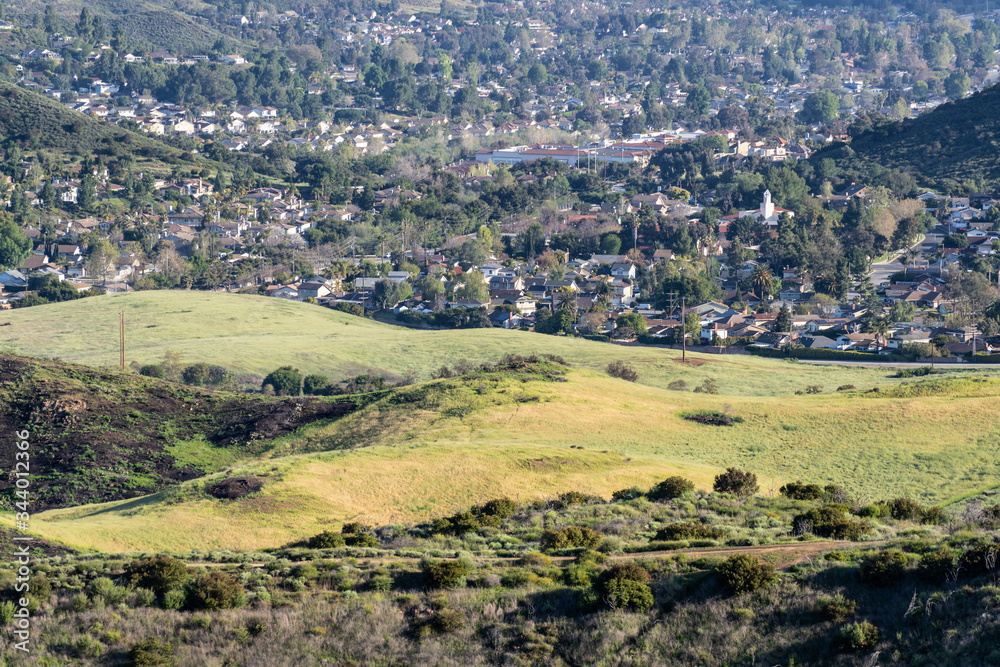 Suburban grasslands meadow with homes in background at Santa Monica Mountains National Recreation Area in Newbury Park, California.