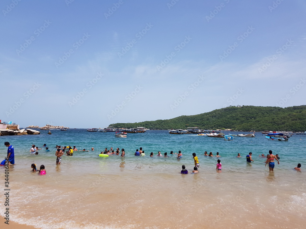 People playing on Caleta beach on a sunny day in Acapulco