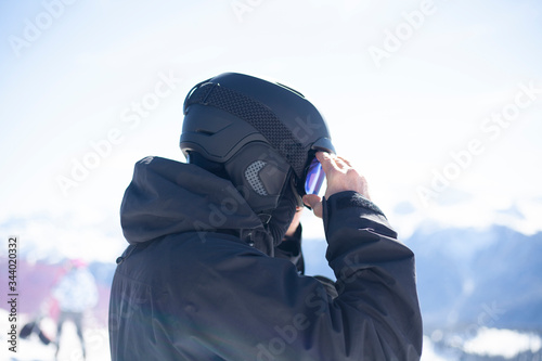 Snowboarder straightens his helmet