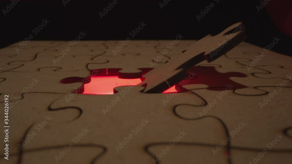 Jigsaw puzzle piece missing with light flashing through the open hole - symbolic element for Autism, business, problem solving, mystery and crime