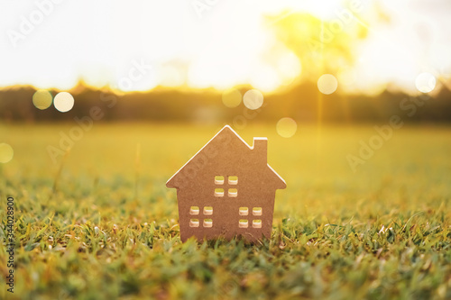 Closed up tiny home model on green grass with sunlight background. © ant