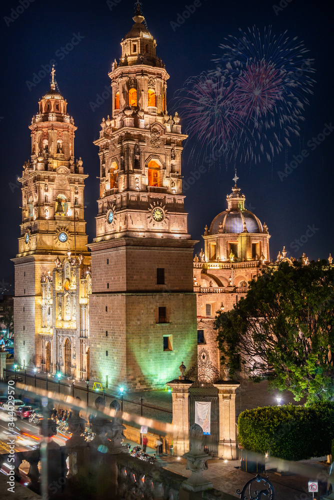 Vista nocturna de la fachada de la catedral de Morelia en el estado de Michoacan Mexico.Al fondo se ven fuegos artificiales
