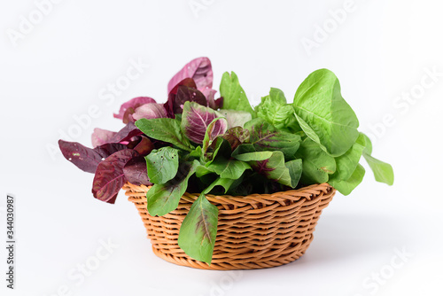 Green and red Thai spinach leaf or edible amaranth (Asian plant) in a basket on white background, Organic vegetable