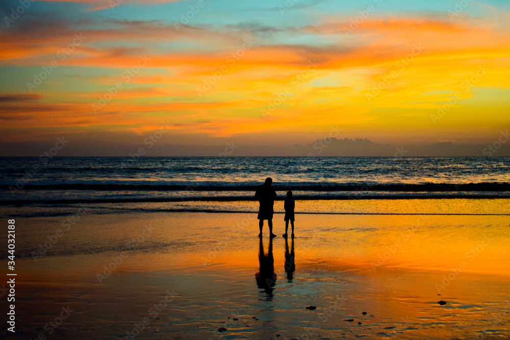 Fototapeta premium sunset on the beach father and son