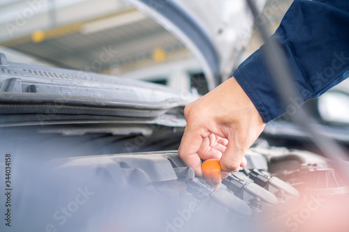 A close up of the hand auto mechanic repair engine in a car repair shop.