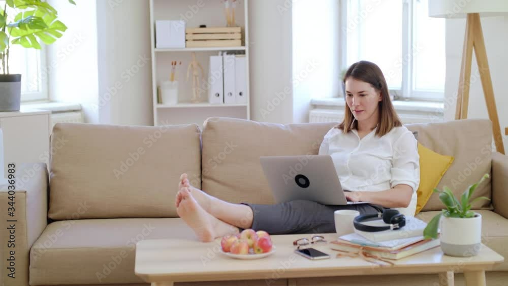 Businesswoman with laptop working in home office, expressing excitement.