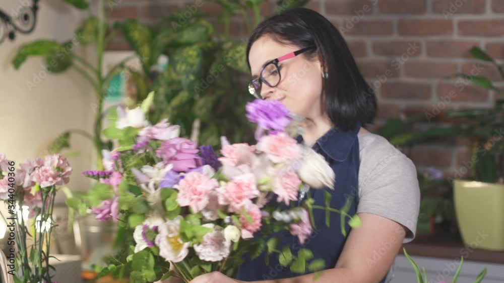 Florist woman made a bouquet of beautiful flowers. Floral art concept. Working girl in store. Professional florist making flowers bunch bouquet in flower shop. Businesswoman small business owner. Florist woman made a bouquet of beautiful flowers. Floral art concept. Working girl in store. Professional florist making flowers bunch bouquet in flower shop. Businesswoman small business owner.