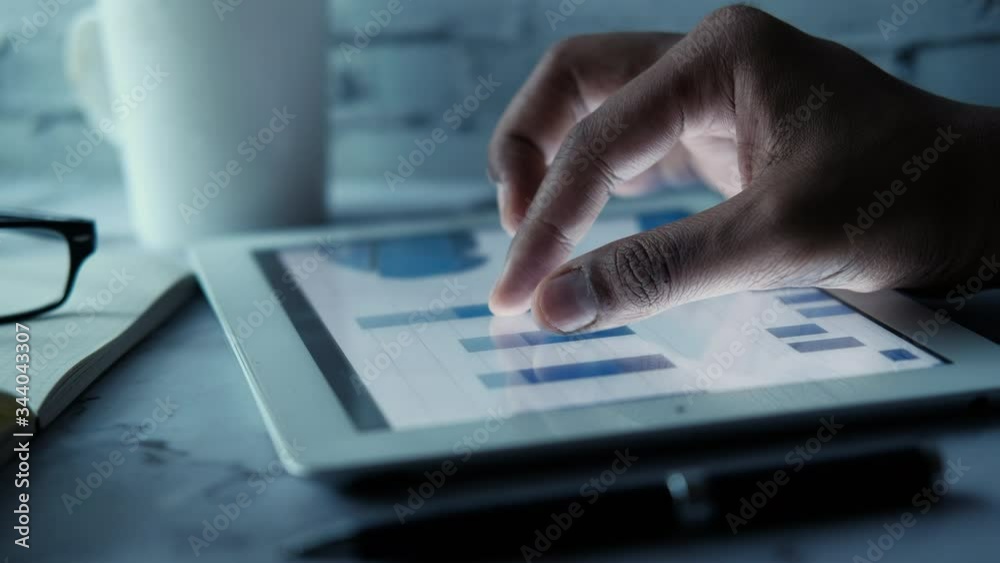 person hand analyzing financial data on digital tablet 