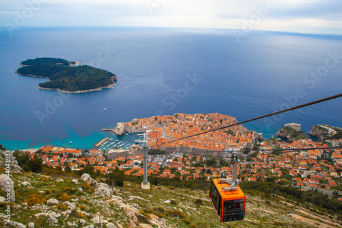 Fototapeta Naklejka Na Ścianę i Meble -  Vista aerea desde el monte Srdj de la muralla y el pueblo de Dubrovnik en Croacia, con montaña y mar. Construida sobre la roca del mar Mediterraneo. Histórico pueblo turístico costero. 