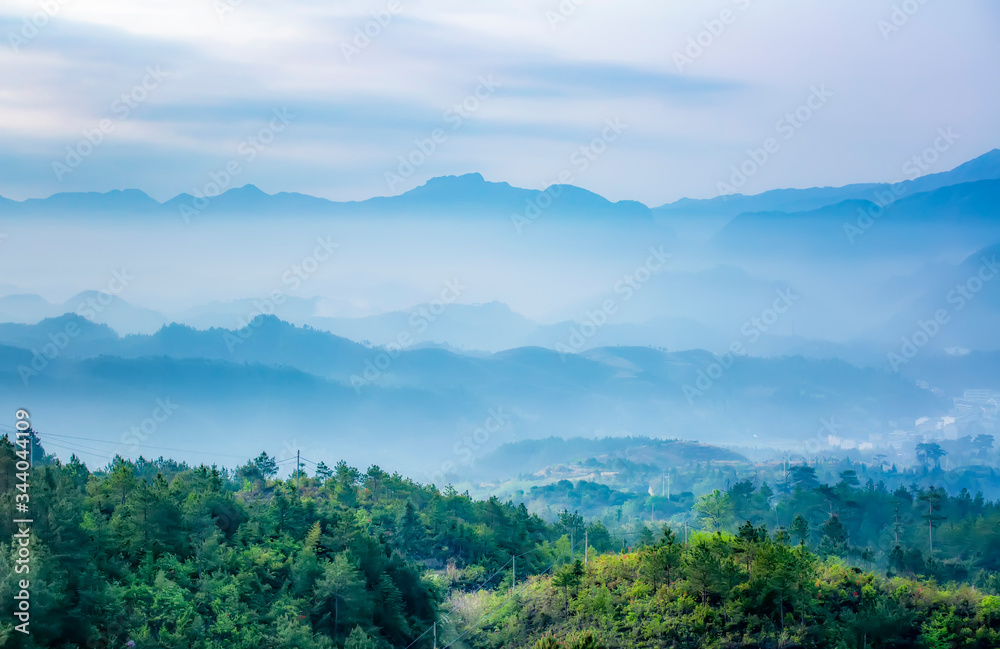 Mountain range with visible silhouettes through the morning colorful fog. Mountain range with visible silhouettes through the morning colorful fog.