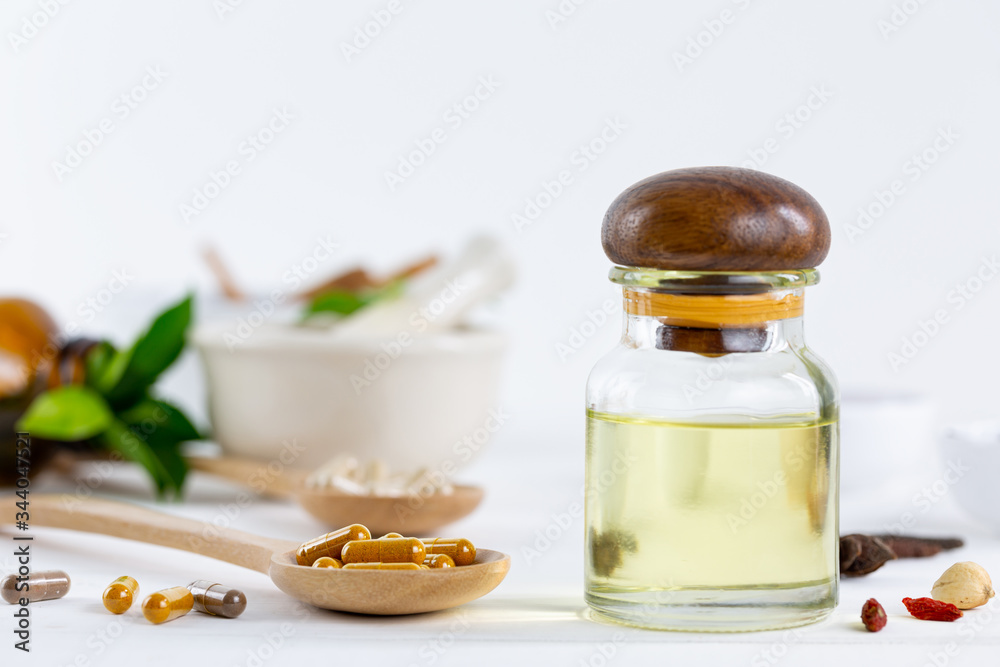 Herbal supplement in capsules on wooden spoon with healthy medicinal plant.Alternative drug or natural pharmaceutical capsule.Medication of vitamin supplemental for care and treatment. Herbal supplement in capsules on wooden spoon with healthy medicinal plant.Alternative drug or natural pharmaceutical capsule.Medication of vitamin supplemental for care and treatment.