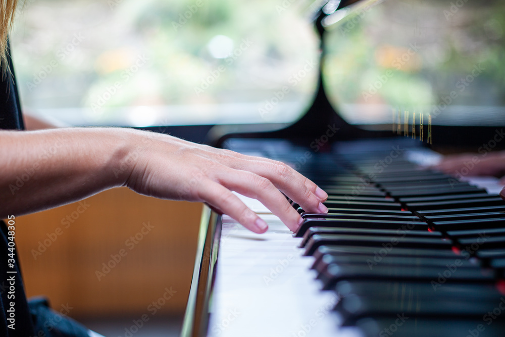 Obraz premium Mano de mujer tocando teclado de piano